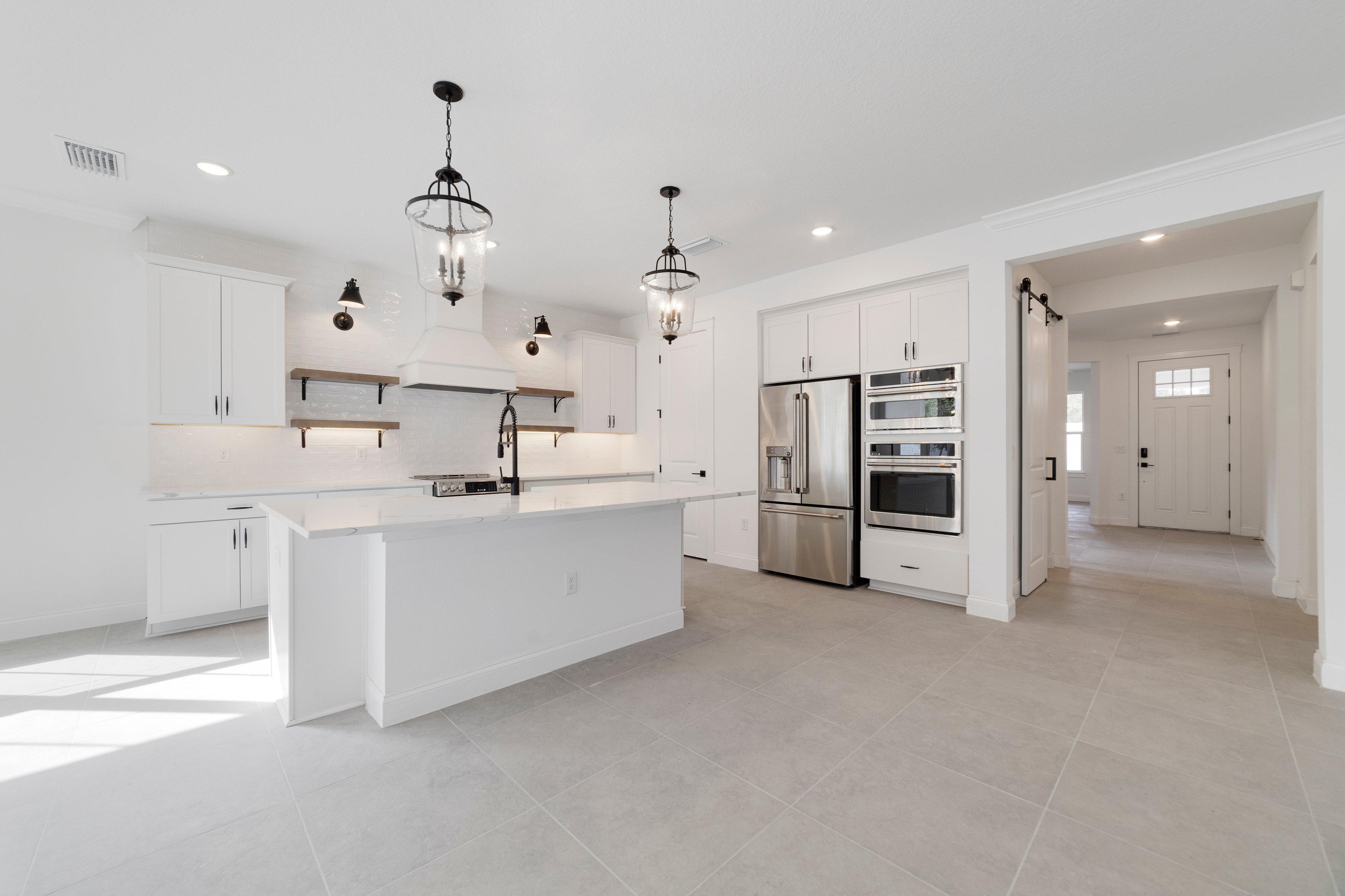 Kitchen with floating shelves and pendant lights