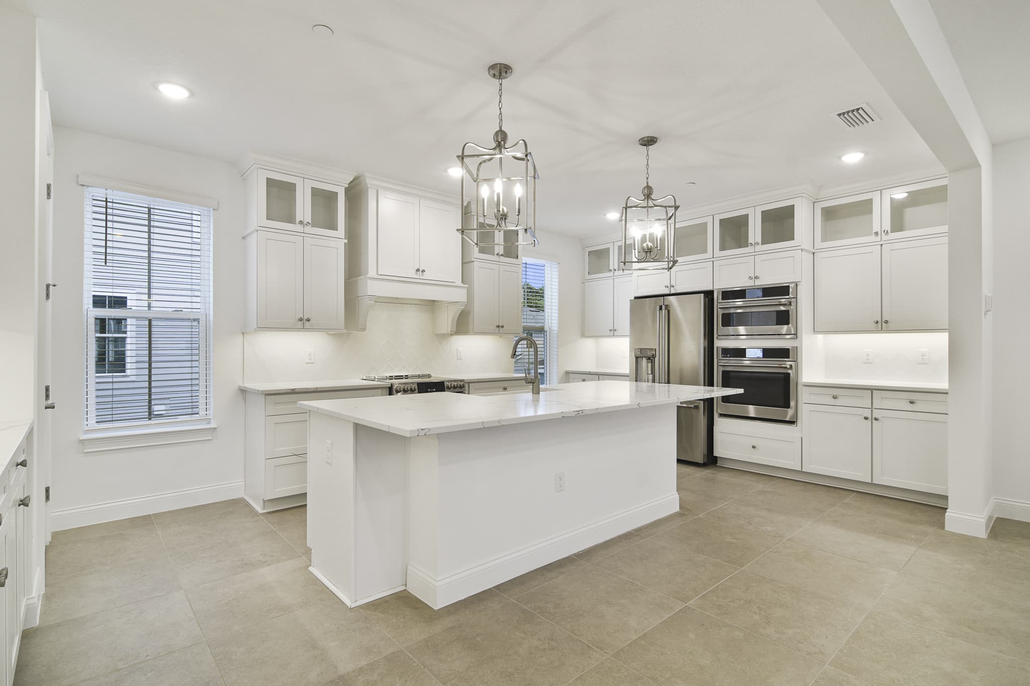 Kitchen features stacked cabinetry with glass-front uppers