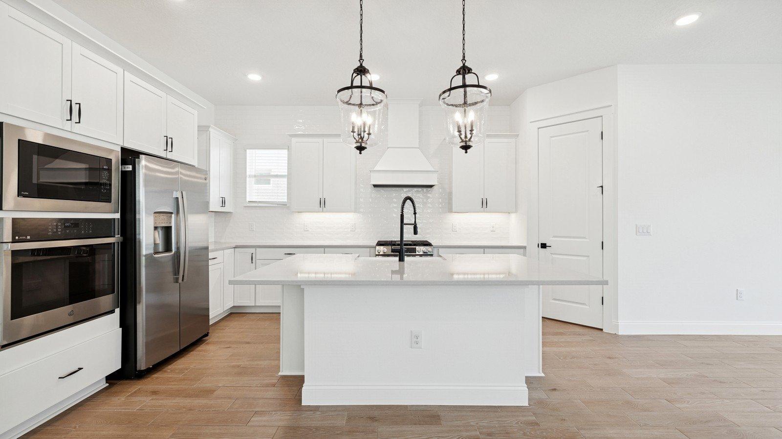 Kitchen with pendant lights & white cabinetry