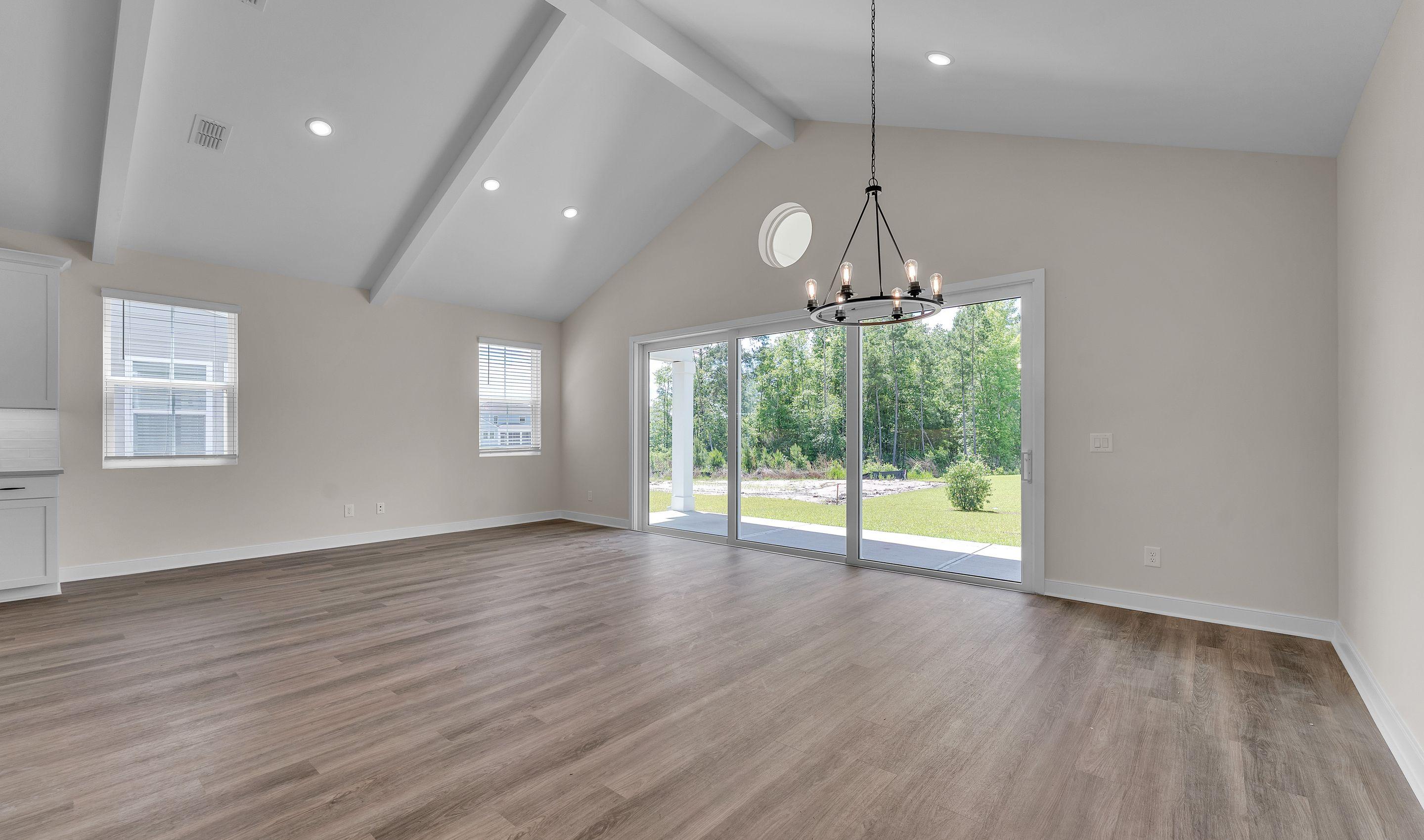 Great room features vaulted ceiling with painted beams