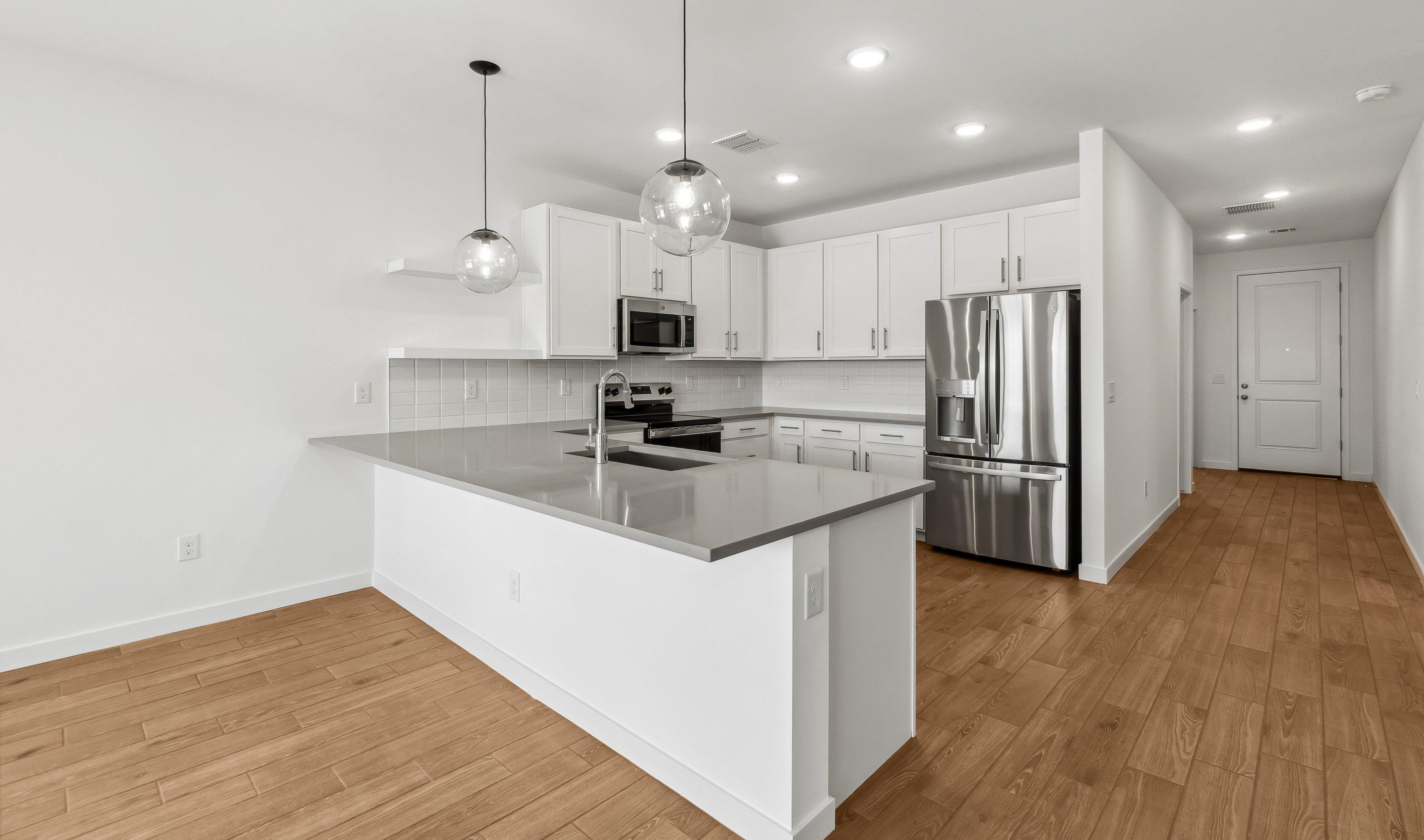 Kitchen with white cabinetry and quartz countertop