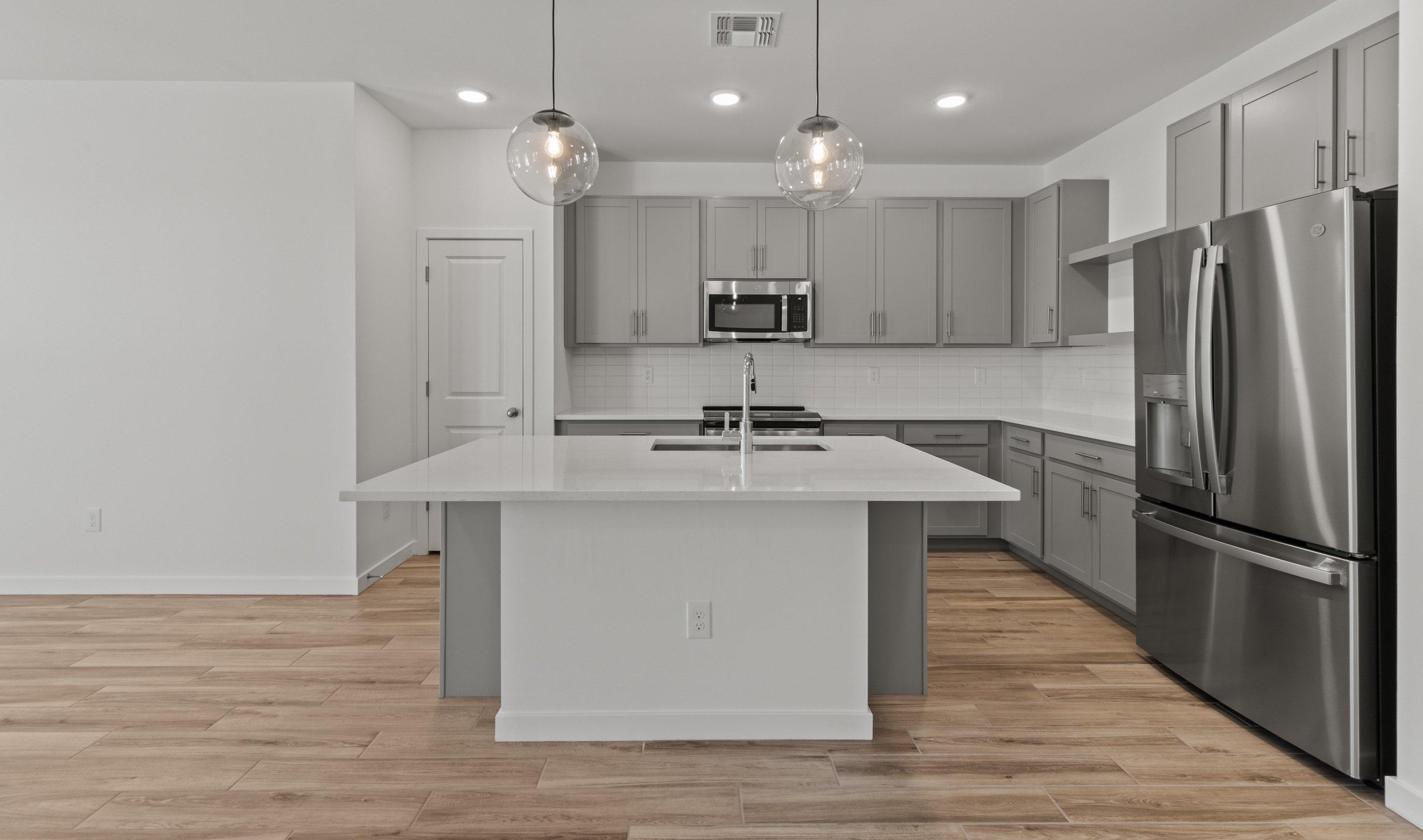 Kitchen with gray cabinets brushed satin nickel finishes