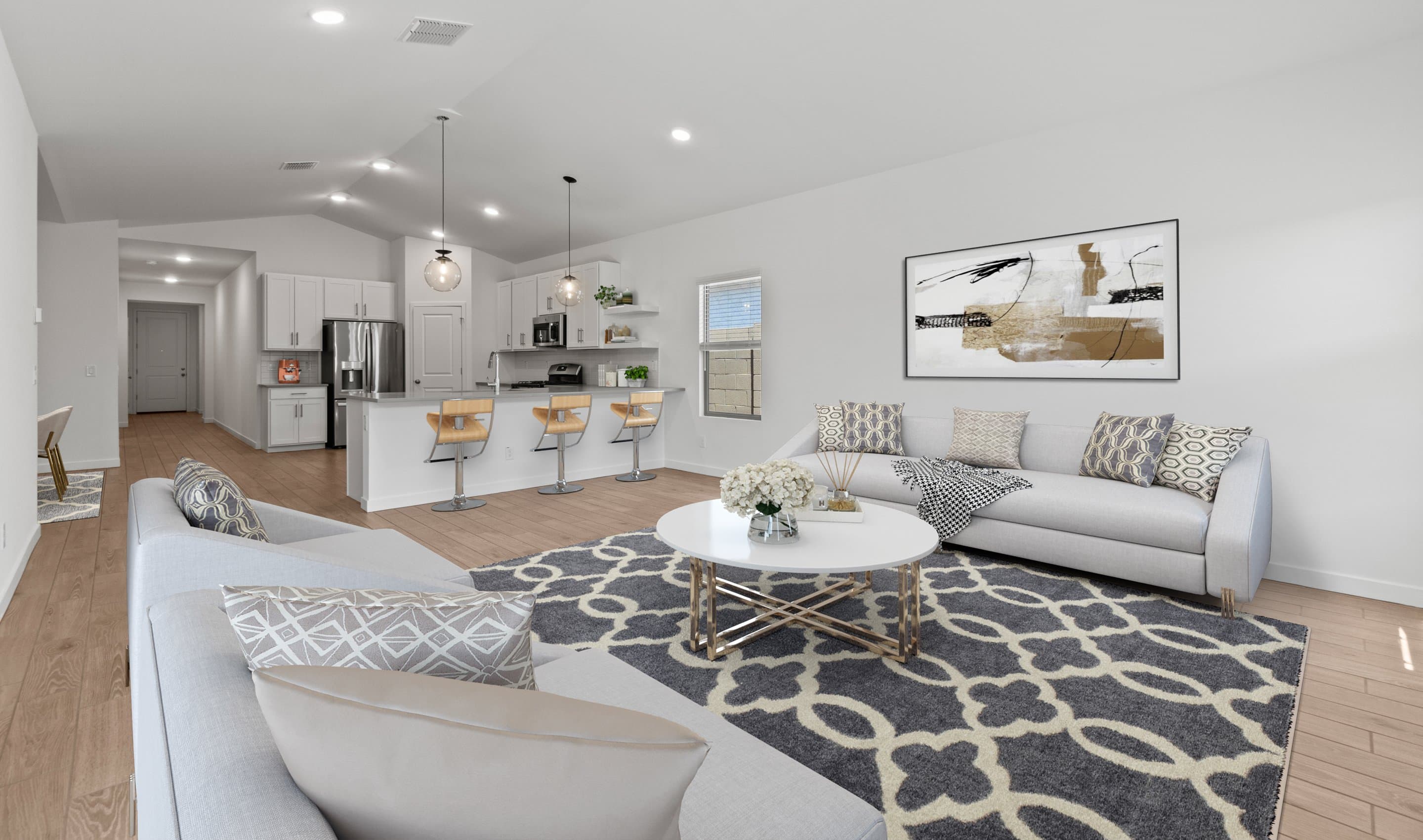 Great room, dining area, & kitchen with soaring vaulted ceiling