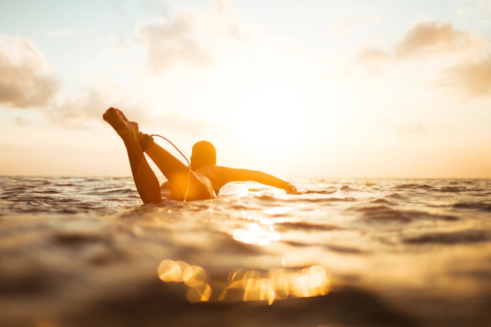 Sunlit Silhouette of Woman Surfing