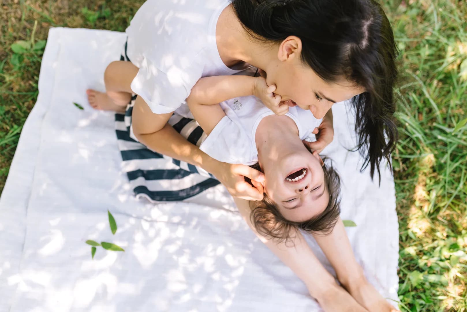 View from above of beautiful happy mother and her little smiling daughter play outdoor