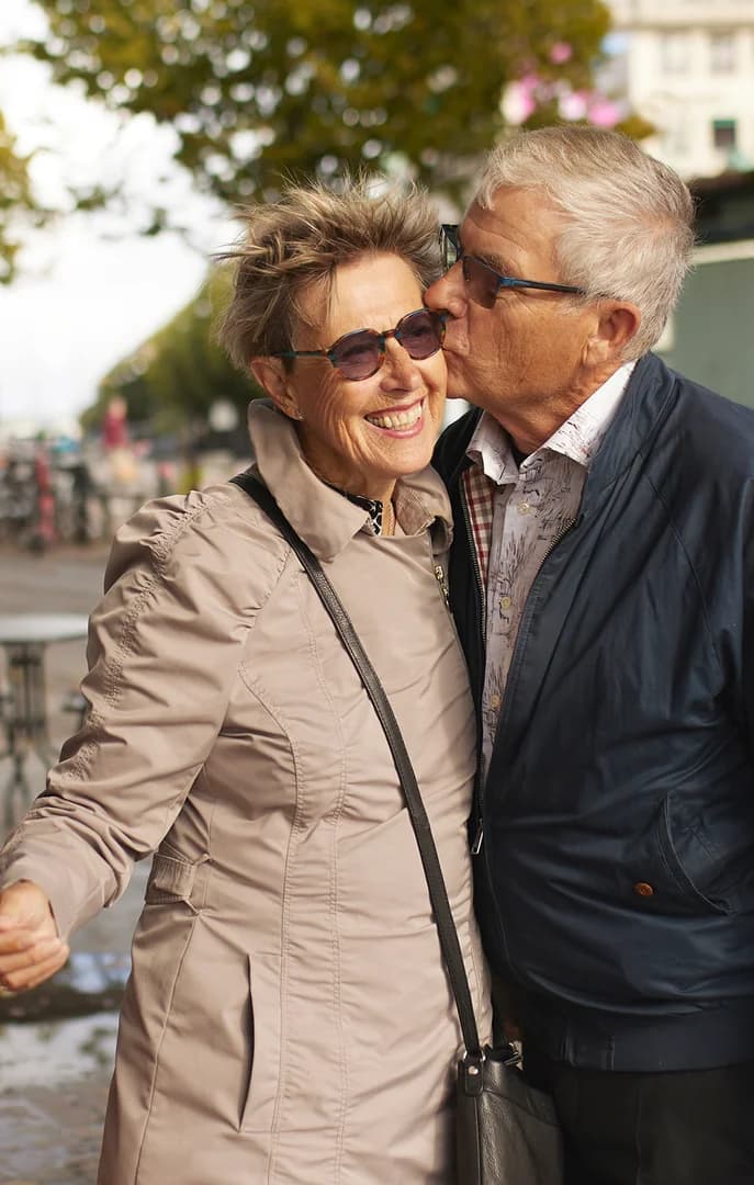 Older Couple Walking Downtown Kissing on Cheek