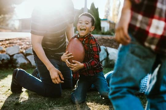 African American Child Playing Outside with Football
