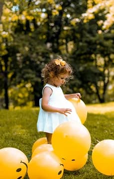 Girl with balloons in a field