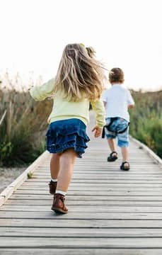 Kids Running Along Boardwalk to the Beach