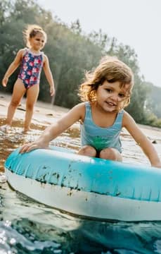 Young Girls Playing at the Lake Shore with Tube