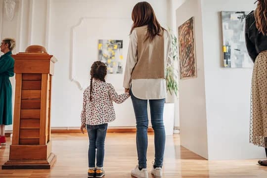 Mom and Daughter Looking at Art in Gallery Holding Hands