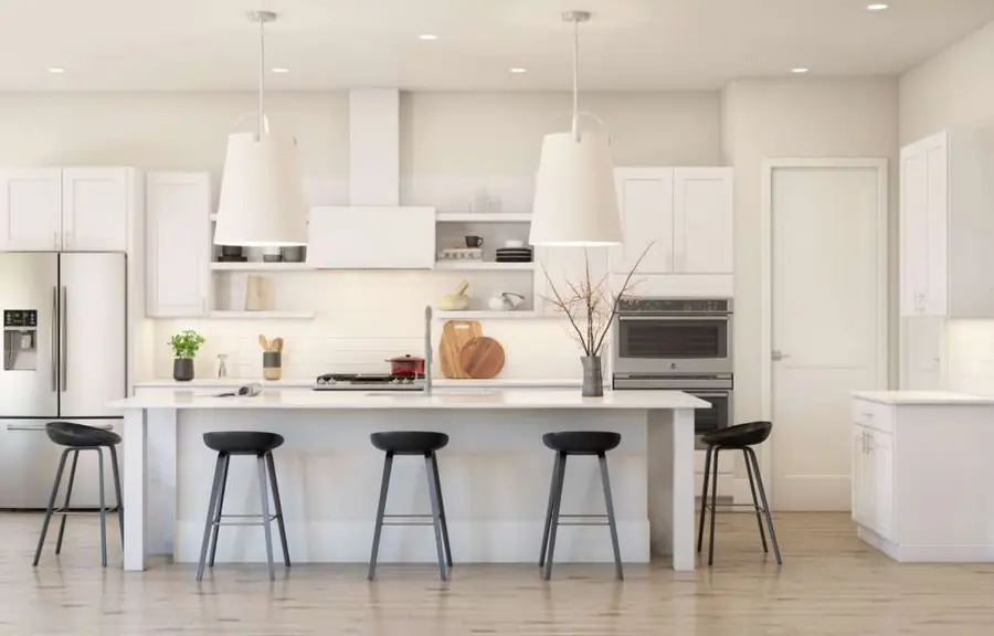 White kitchen with island and two large light fixtures and stools facing the wall with appliances