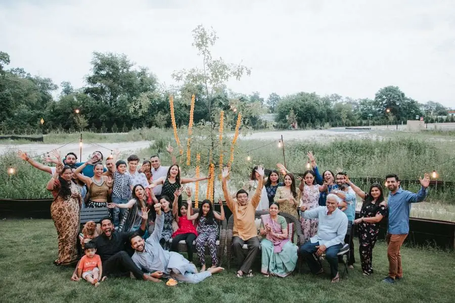 Amit and Aditya with their family and friends on the clubhouse grounds